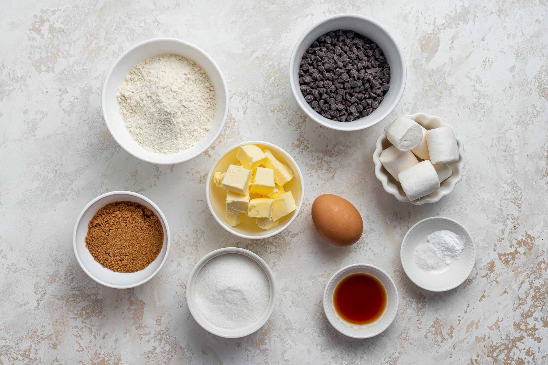 Ingredients for cookies with marshmallows on white table.