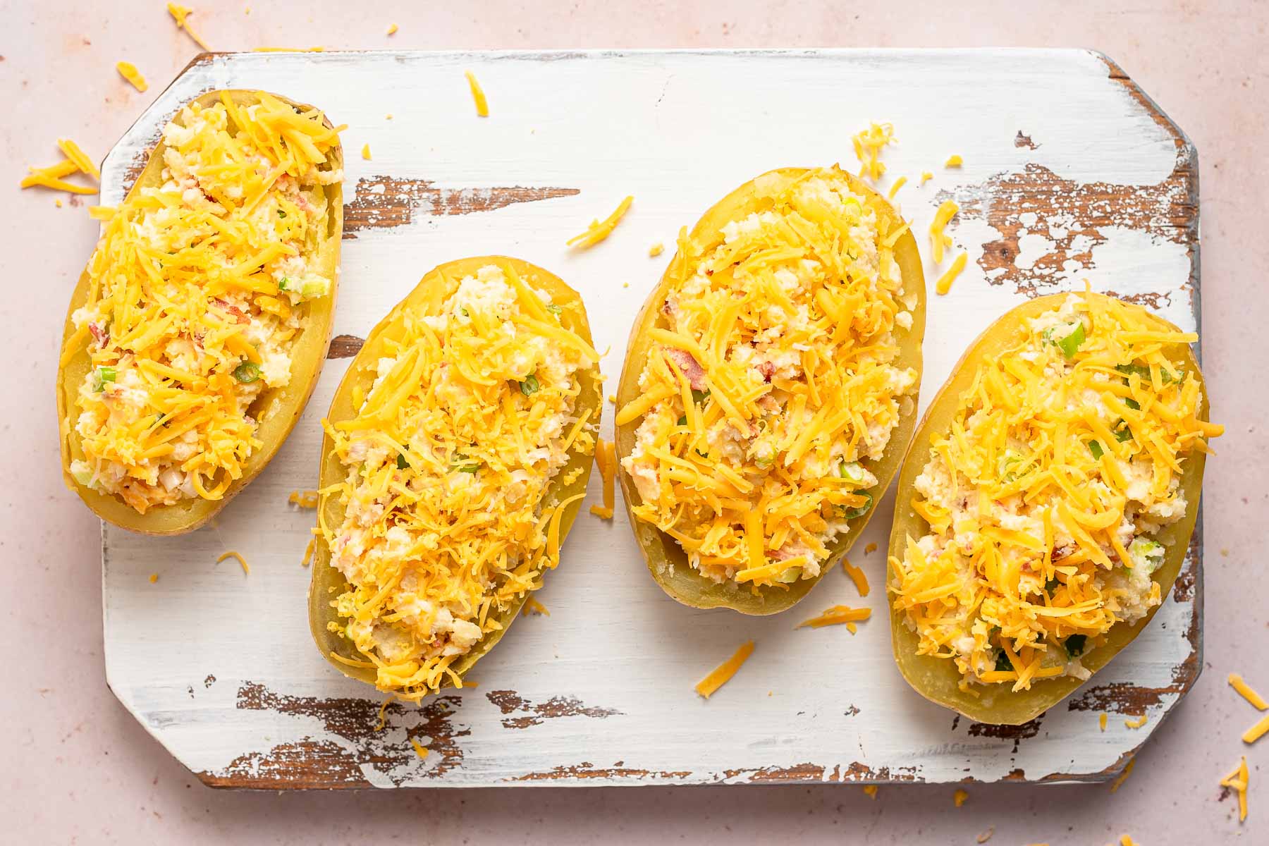 Baked potatoes cut in half and topped with cheese.