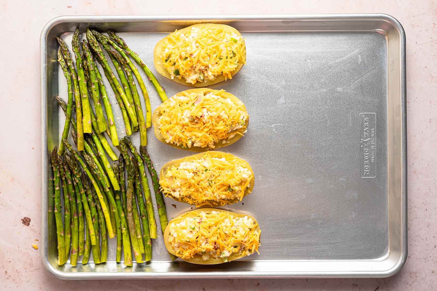 Asparagus and potatoes on a baking sheet.