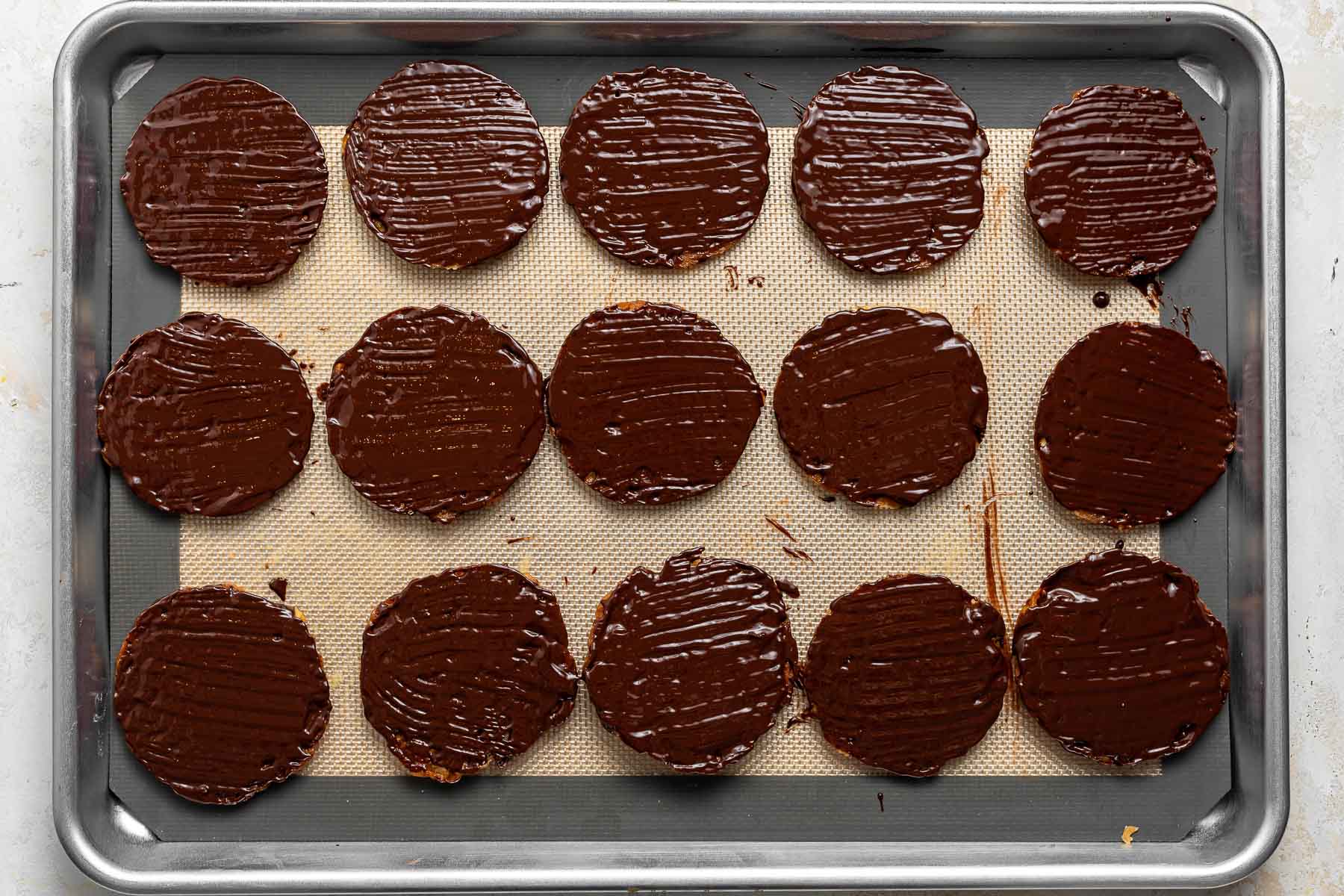 Chocolate dipped cookies on a cookie sheet.