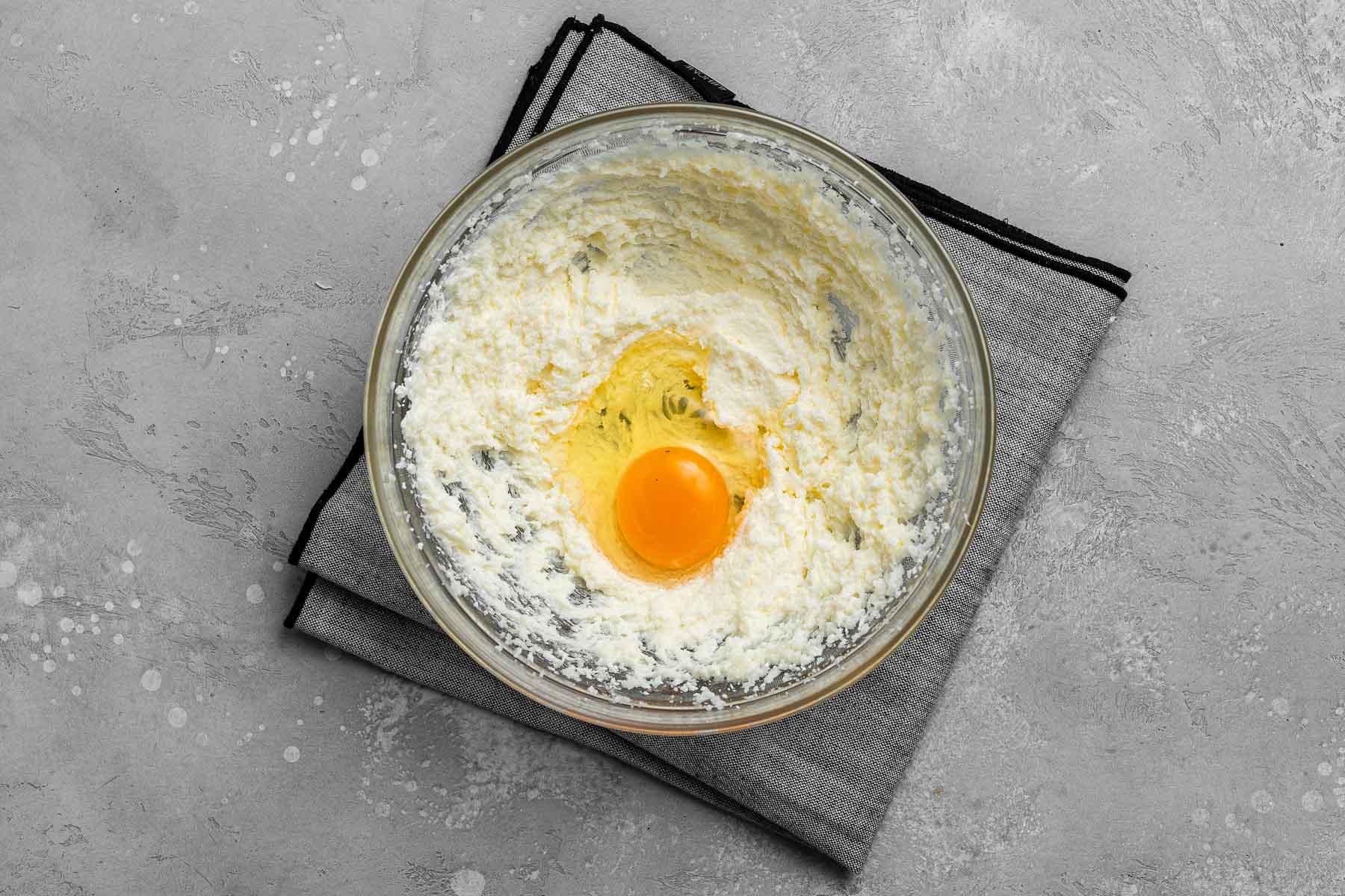 Egg into cake batter bowl.