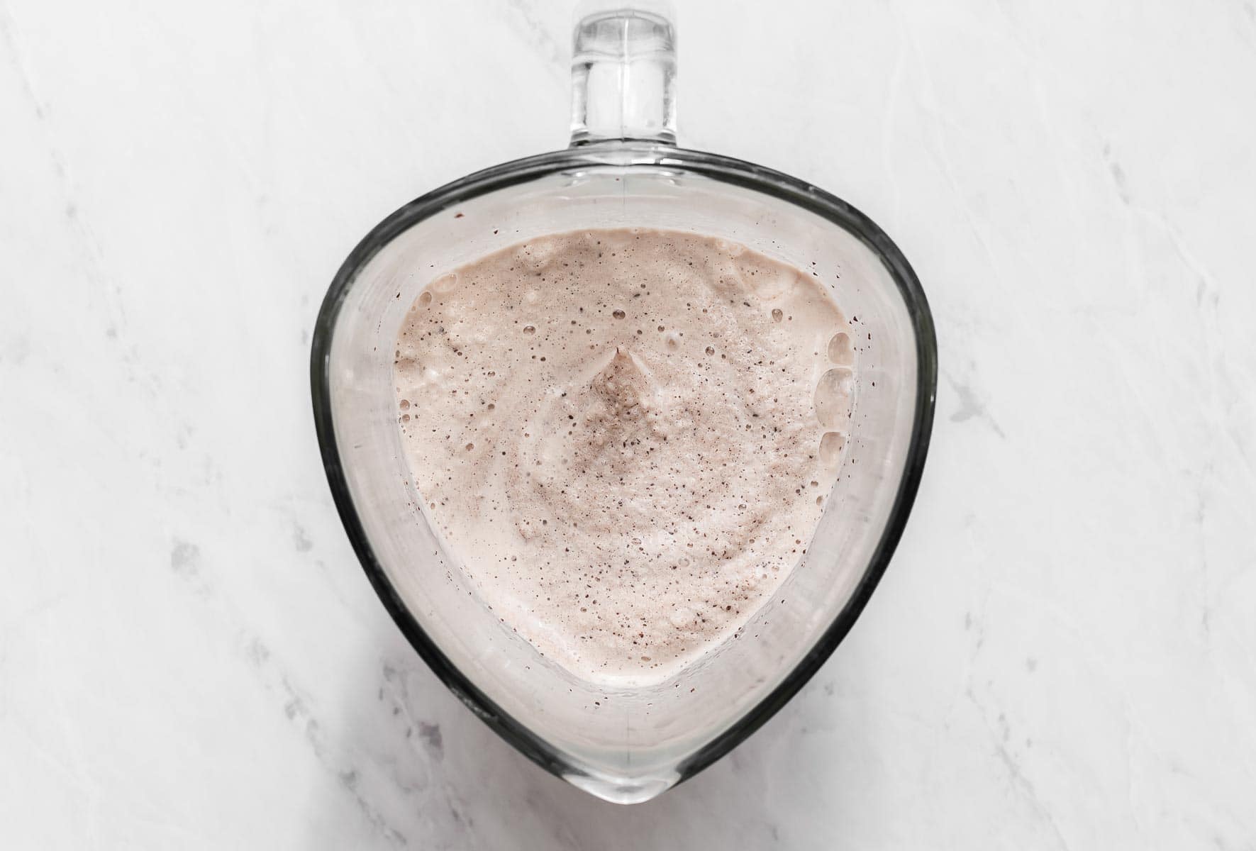 Overhead shot of a light brown smoothie in a blender.