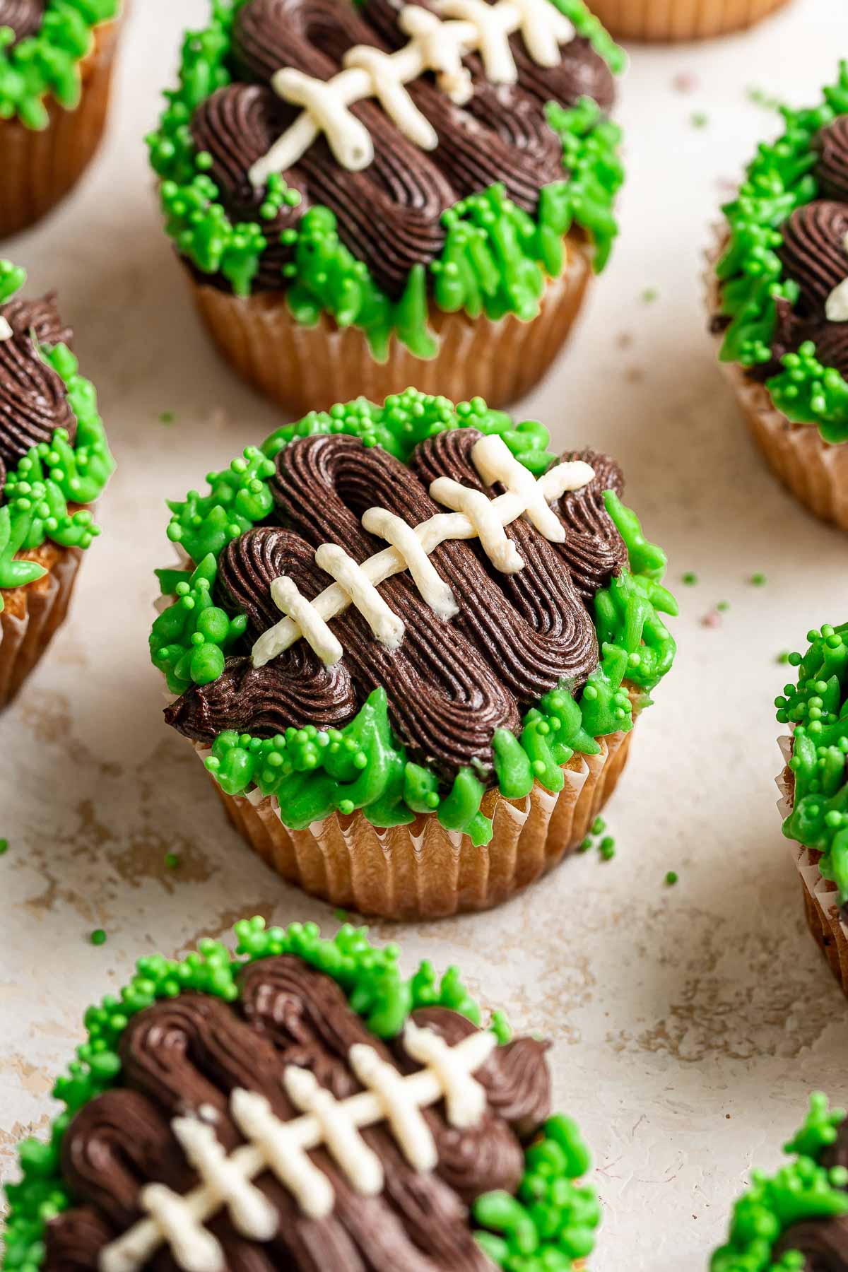 Close up of cupcakes decorated to look like footballs with green grass.