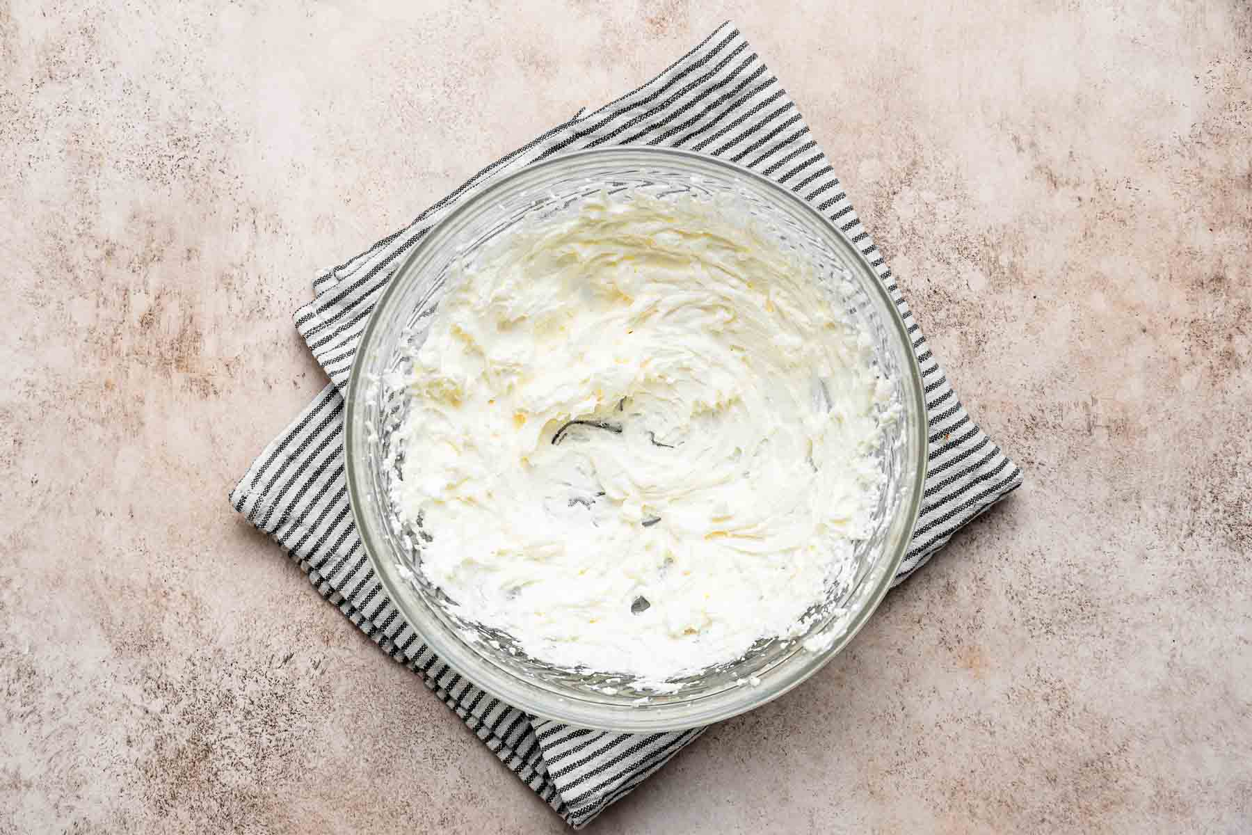 Beaten butter and cream cheese in a clear bowl.
