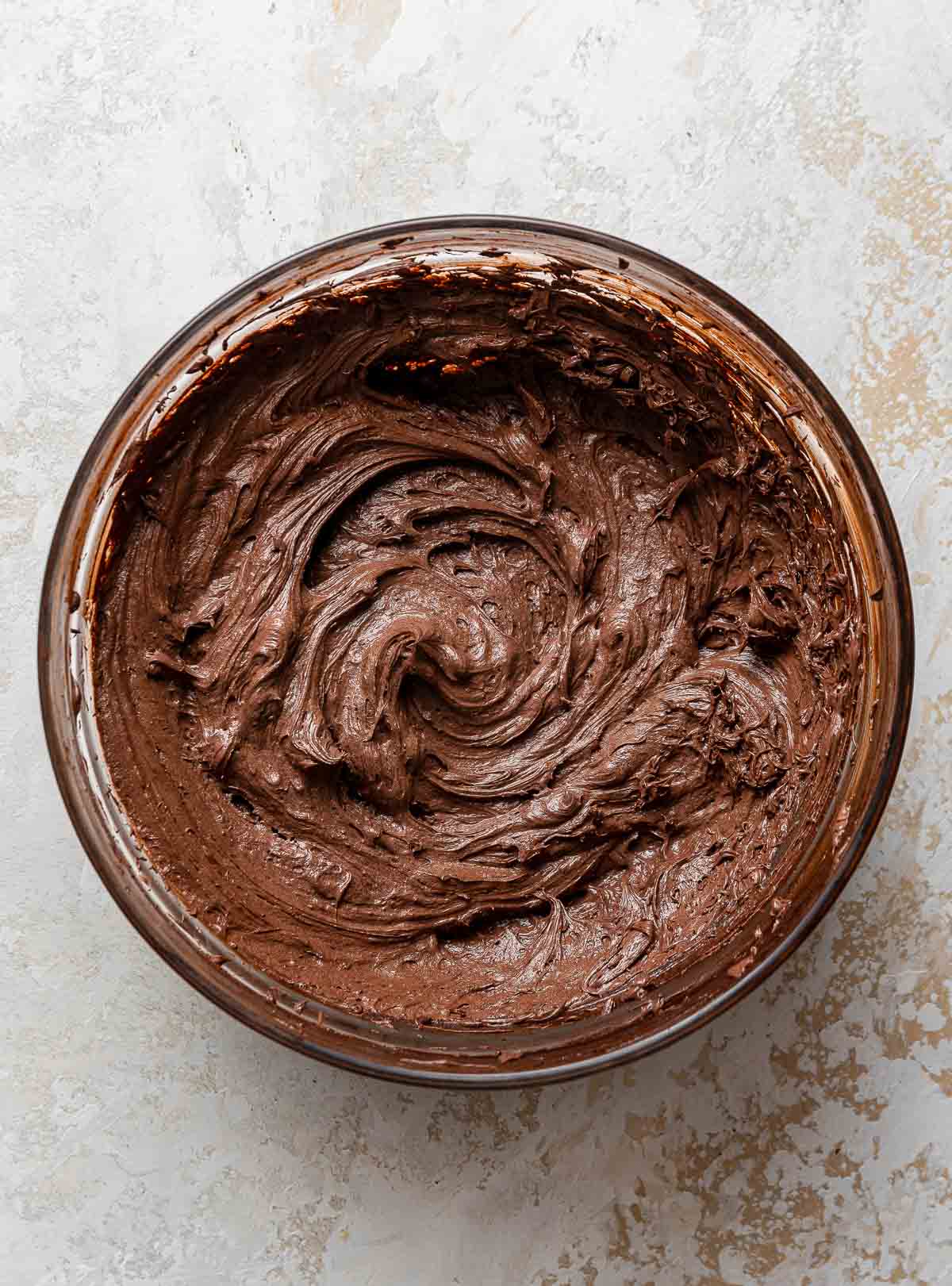 Round bowl of whipped chocolate frosting.
