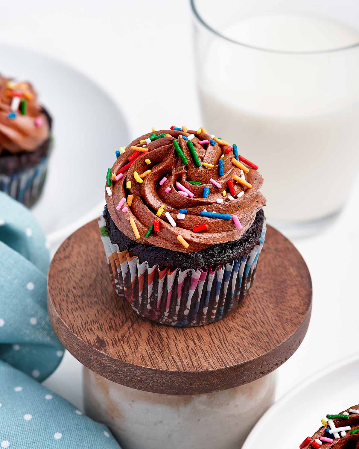 Chocolate cupcake with chocolate swirled frosting and sprinkles.