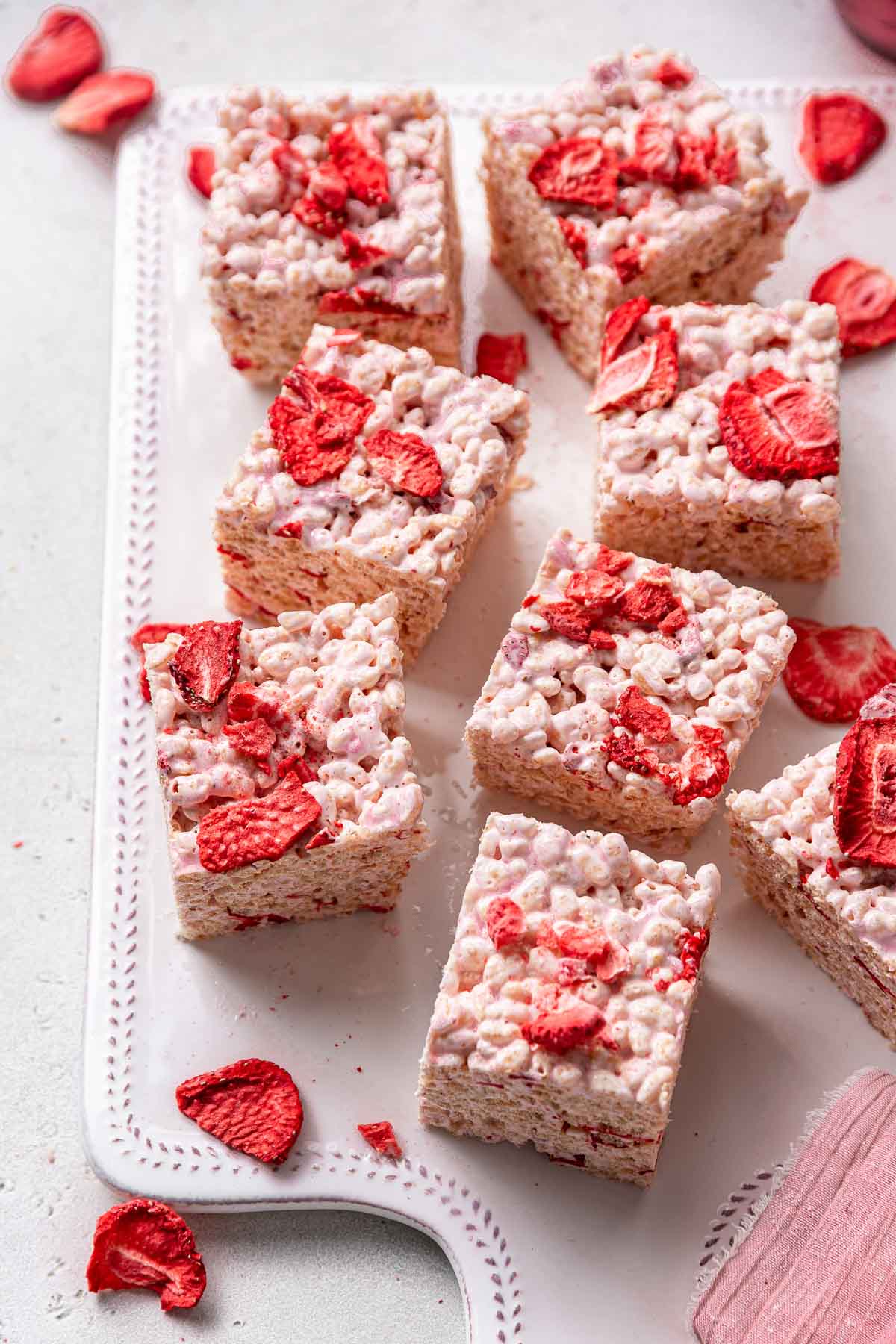 Strawberry Rice Krispie treat squares with freeze dried strawberries on top.