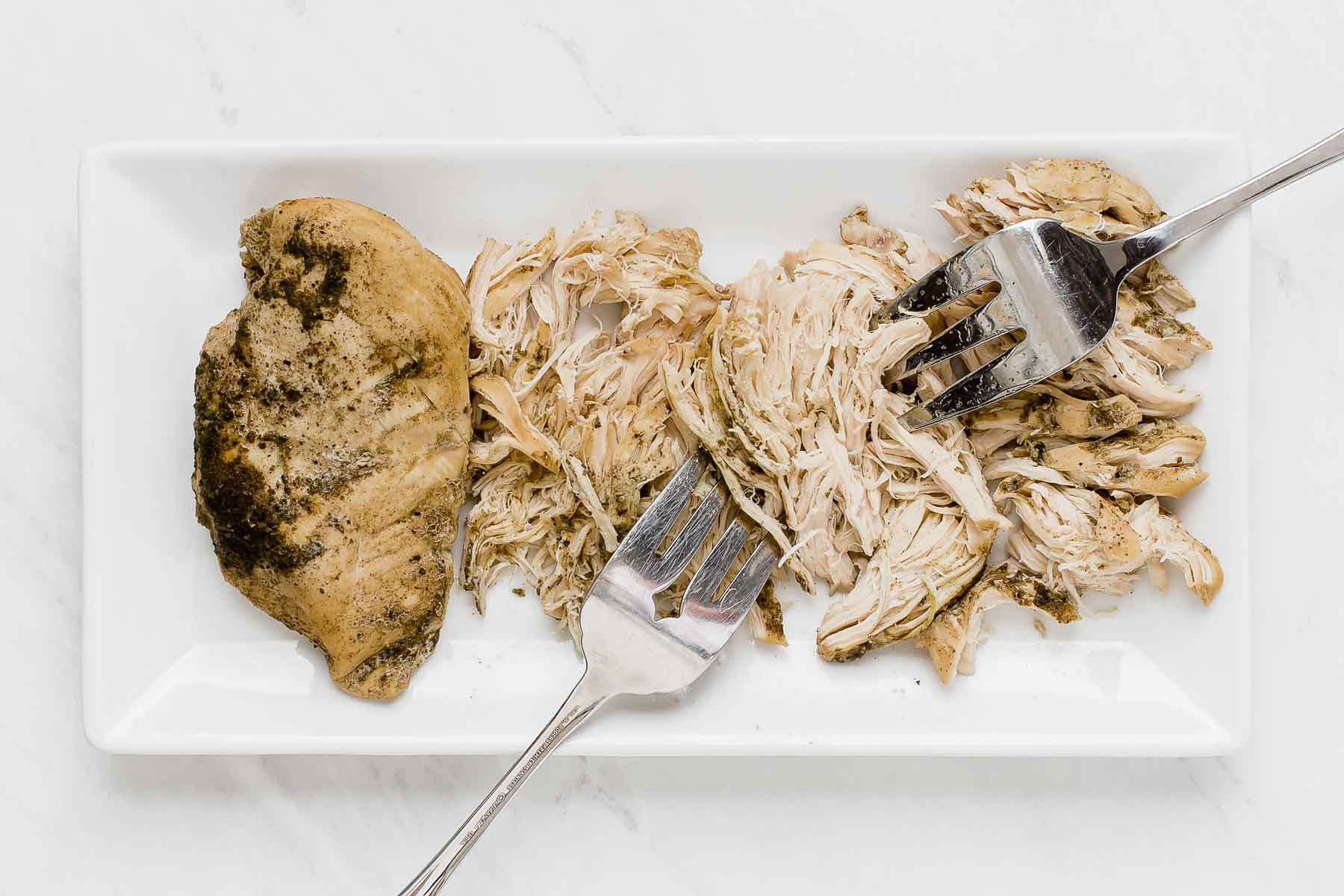 Shredding chicken with two forks from crockpot.
