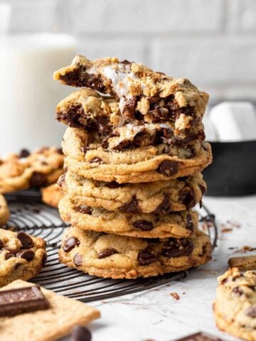 Stack of smores cookies with one split open on top, marshmallow leaking.