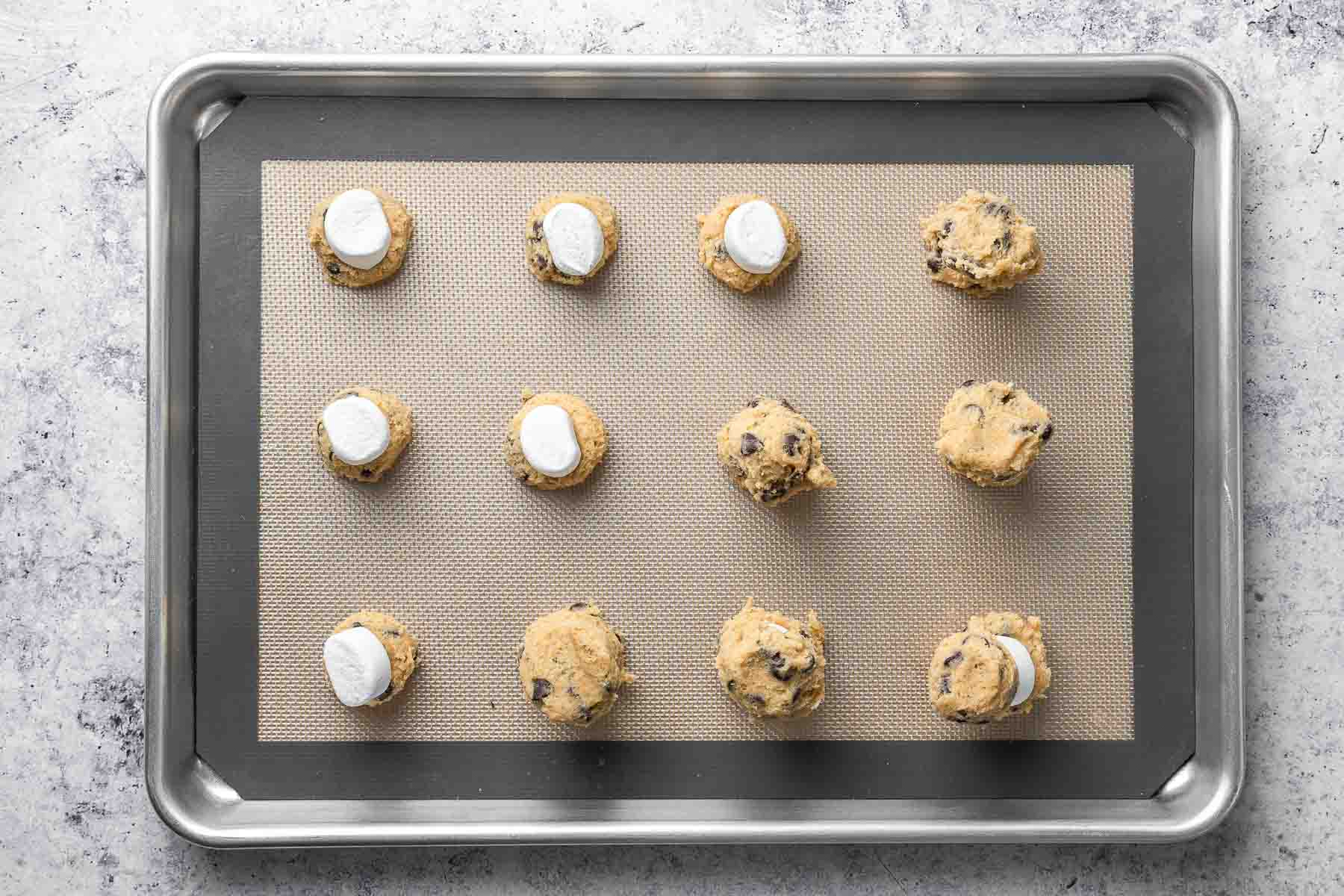 Stuffing chocolate chip cookie dough balls with marshmallows to make smores cookies.
