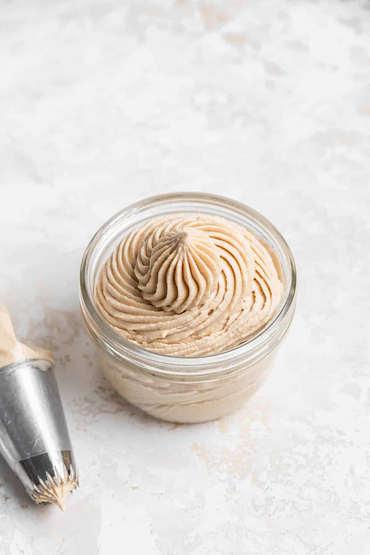 Glass bowl of piped brown sugar cream cheese frosting.