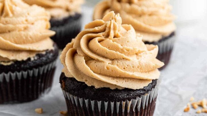 Four chocolate peanut butter cupcakes on grey tray.