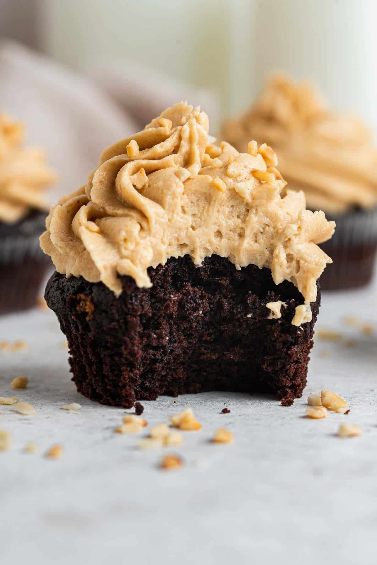 Close up of chocolate peanut butter cupcake with bite missing.