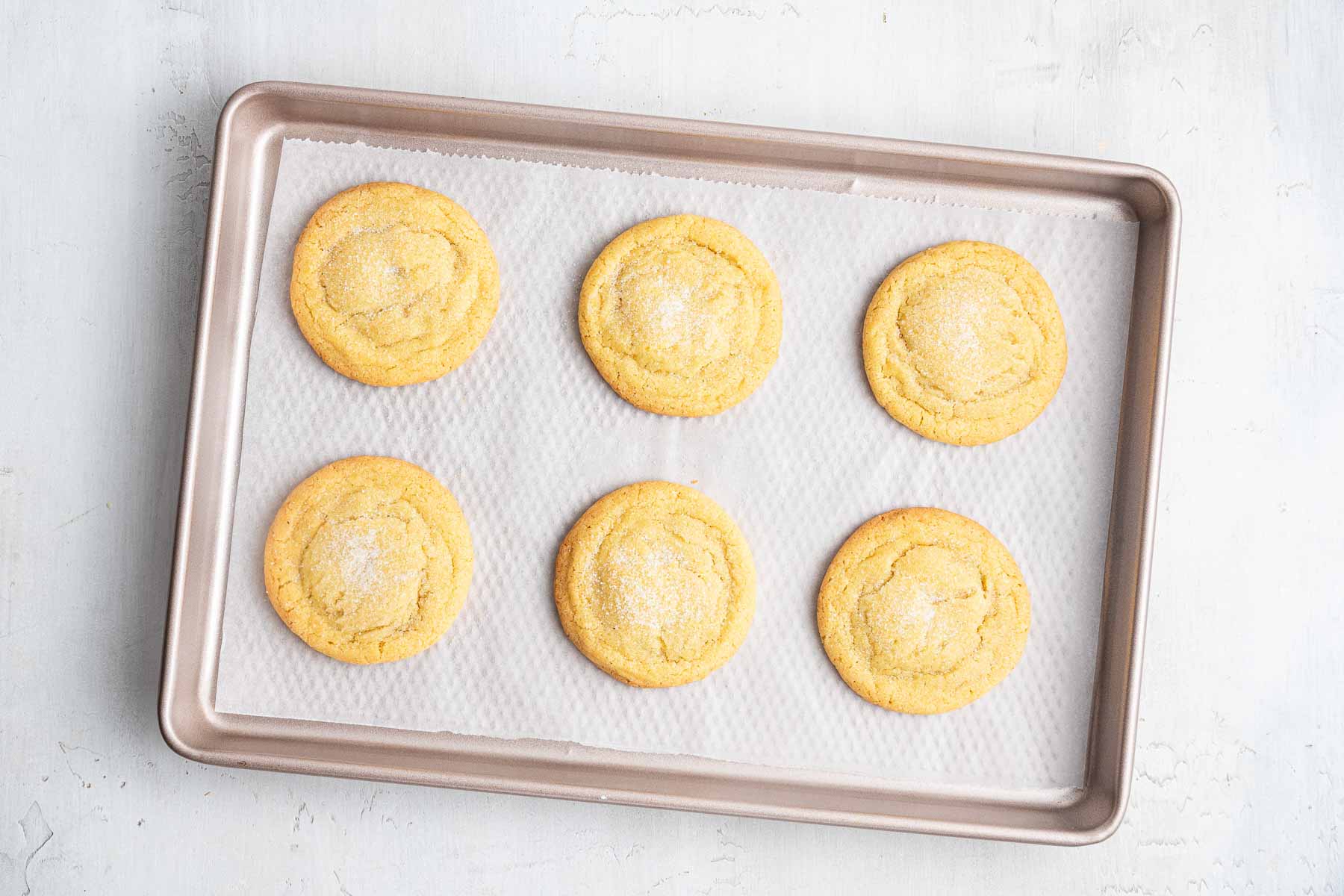 Six easy small batch sugar cookies baked on cookie sheet.