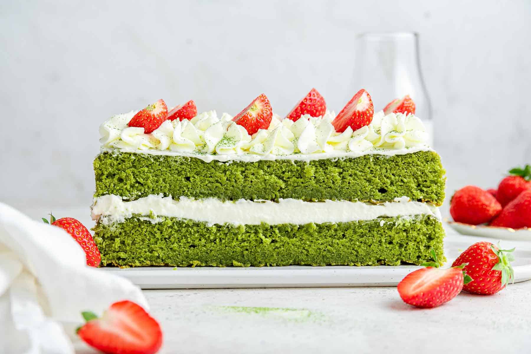 Side shot of a green layer cake made from a square pan.