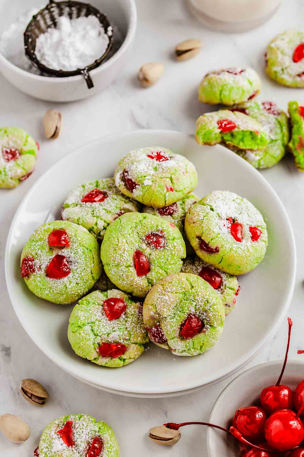 Overheat shot of pistachio pudding cookies with bright red cherries studded throughout.
