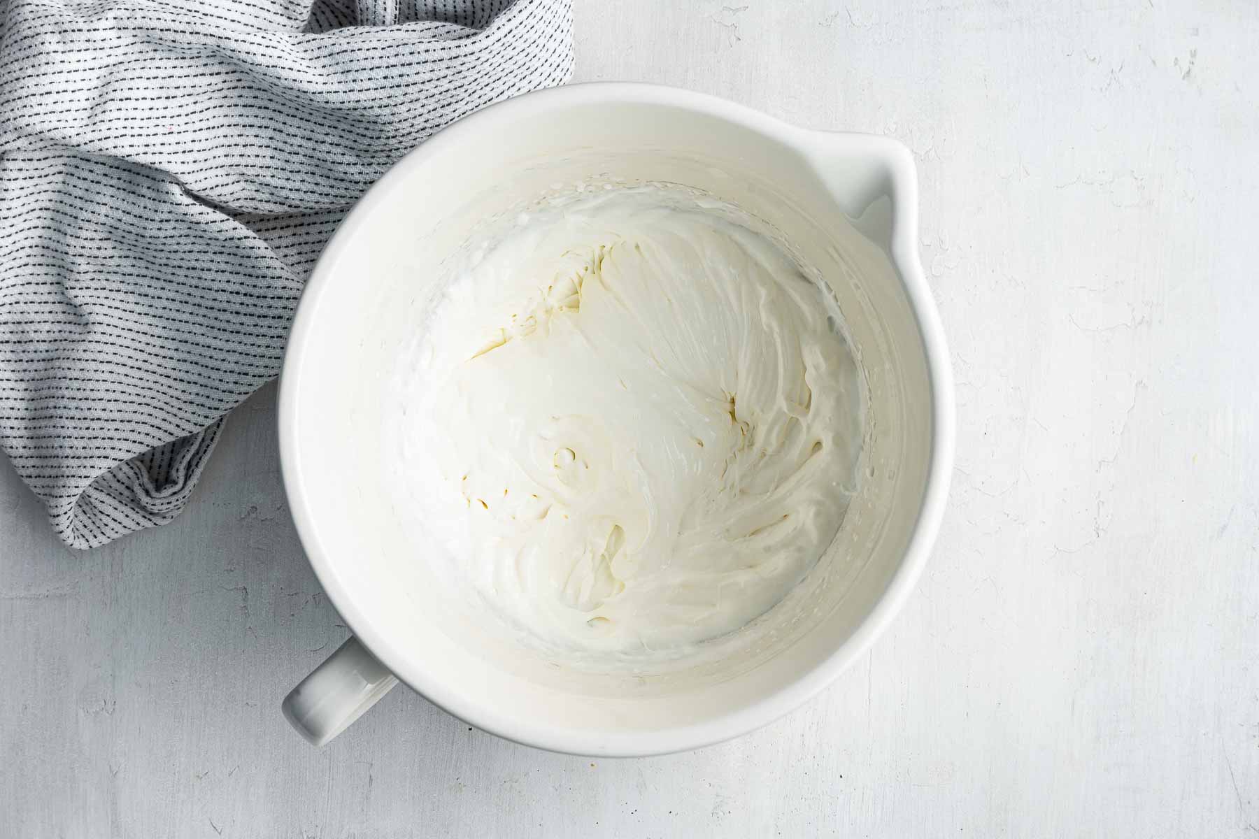 Heavy whipping cream in a white bowl.