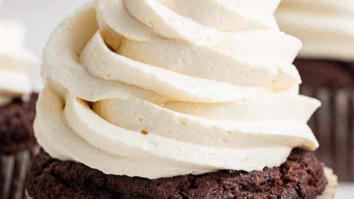 Close up photo of white swirled marshmallow frosting on a chocolate cupcake.