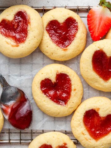 Close up of strawberry jam cookies with red heart shaped centers.