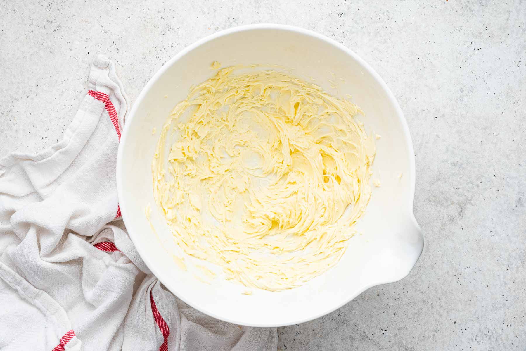 Butter, beaten until fluffy in a white bowl.