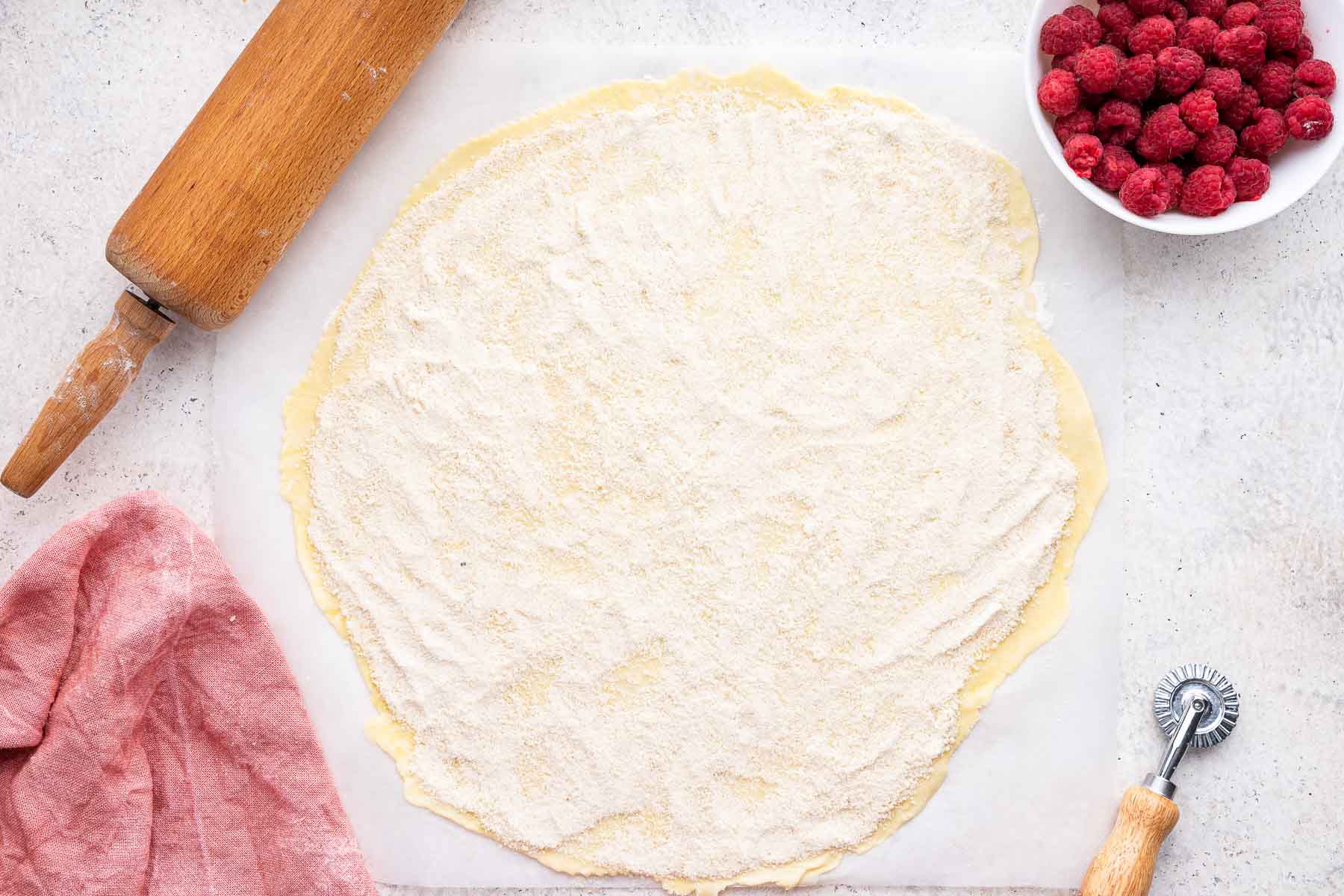 Round pie crust rolled out with flour and sugar on top.