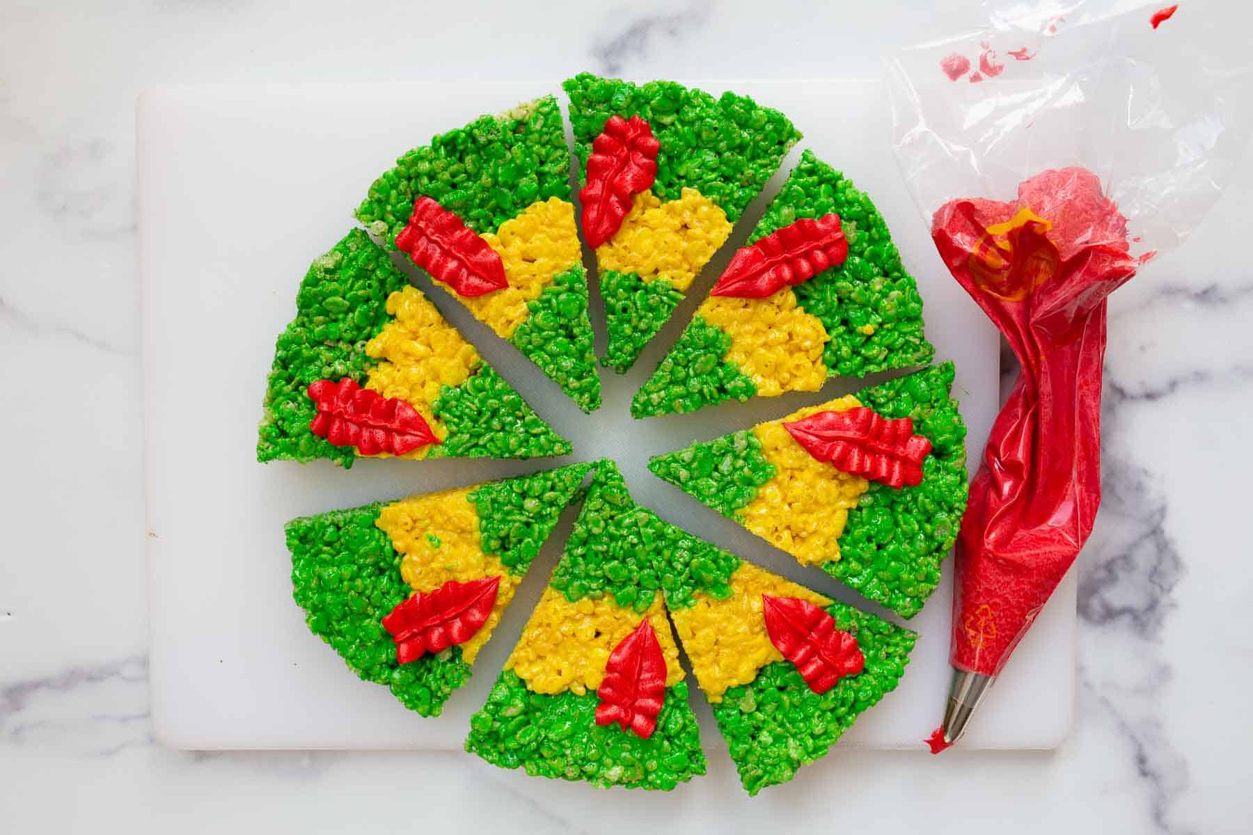 Red feathers piped on green and yellow triangle desserts.