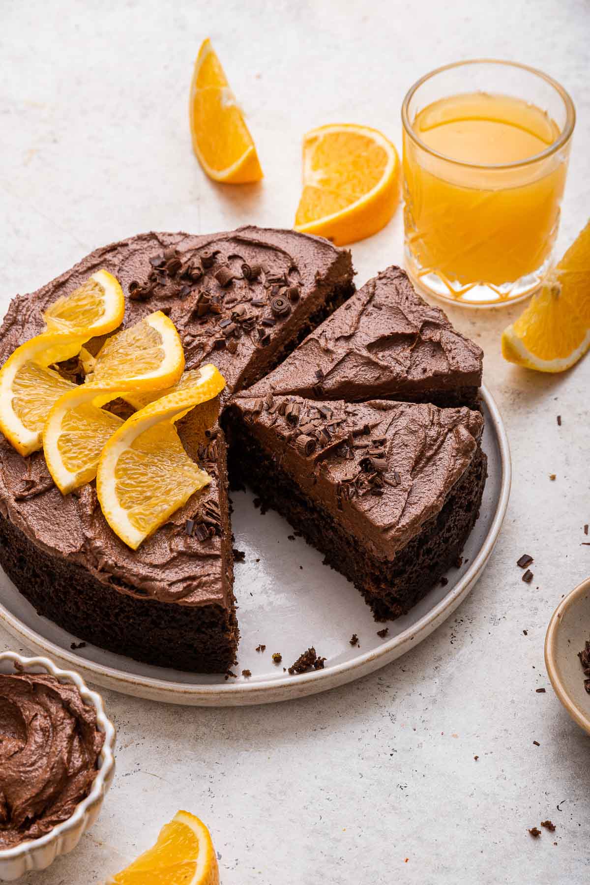 Round orange chocolate cake with chocolate frosting and orange slices on top.