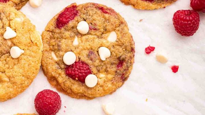 Overhead vertical shot of white chocolate raspberry cookies on white counter.