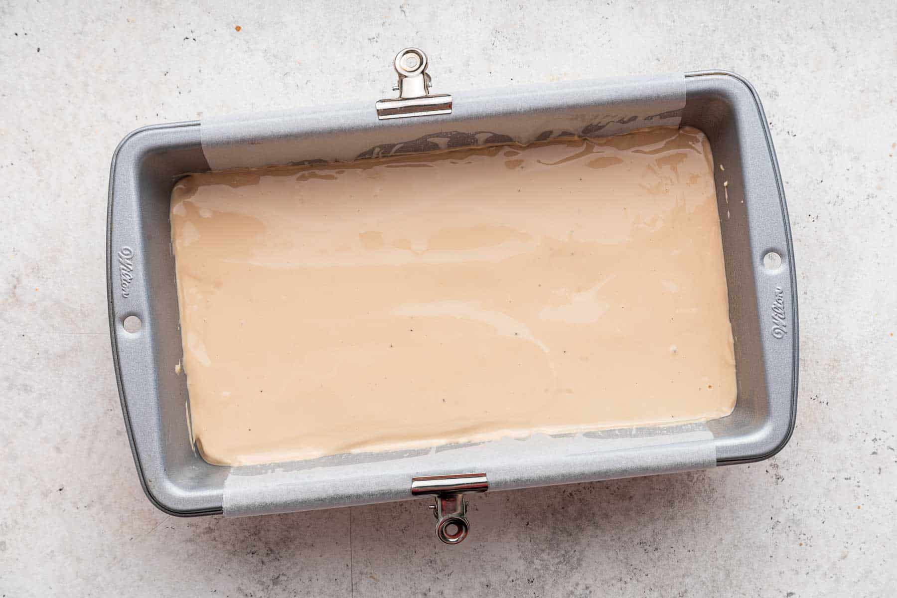 Brown coffee cheesecake batter in a loaf pan.