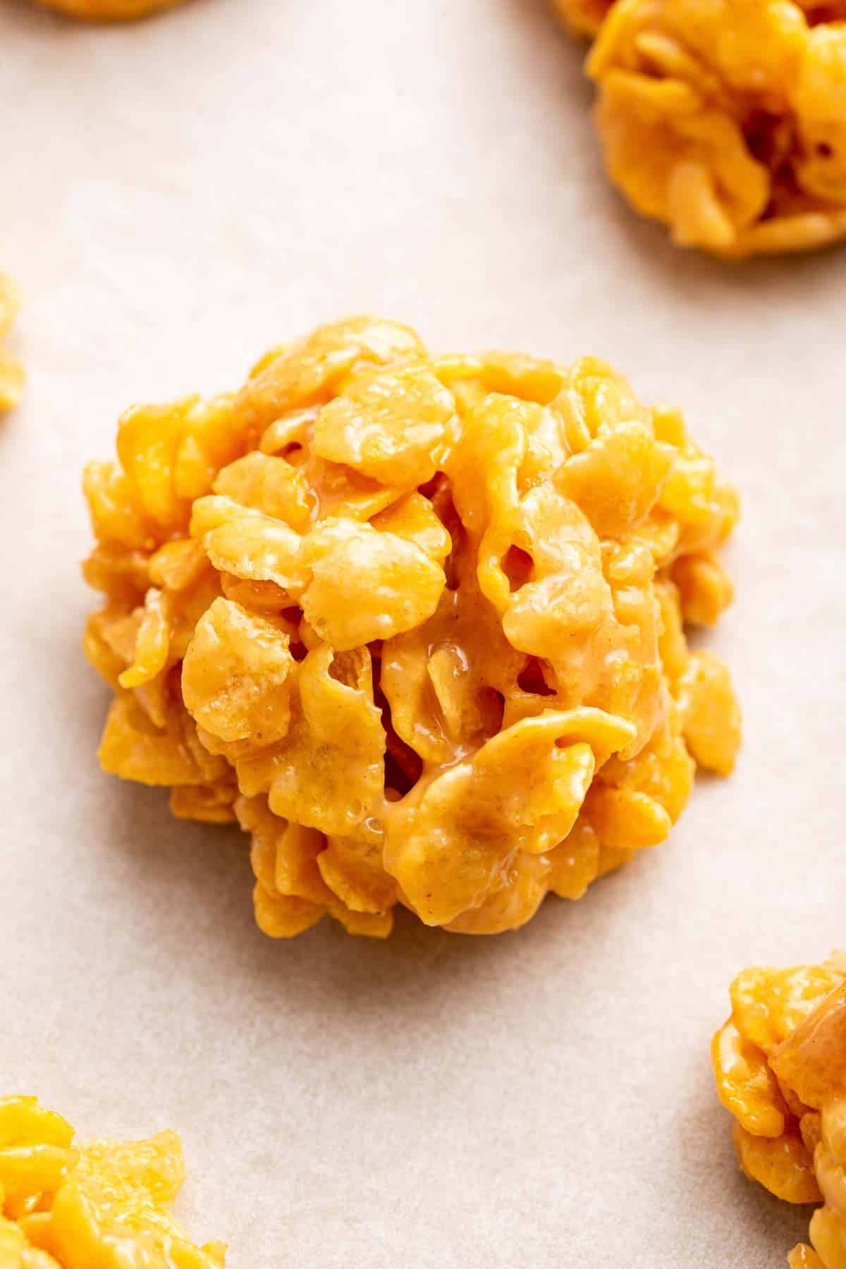 Macro image of cornflake cookie on white parchment paper.