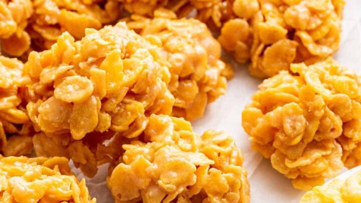 Vertical image of cornflake cookies on white cutting board.