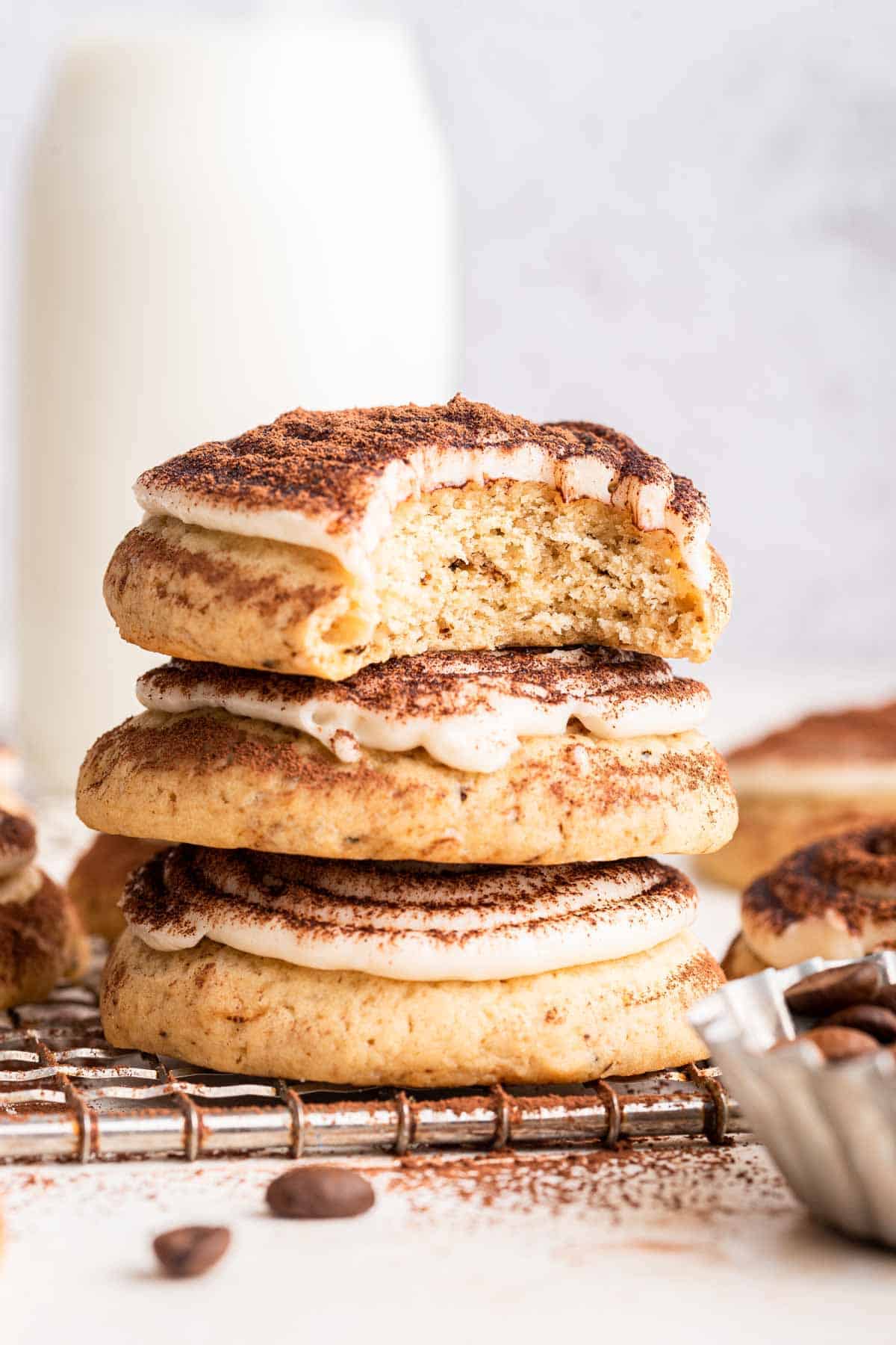 A stack of tiramisu cookies with a bite missing from the top cookie.