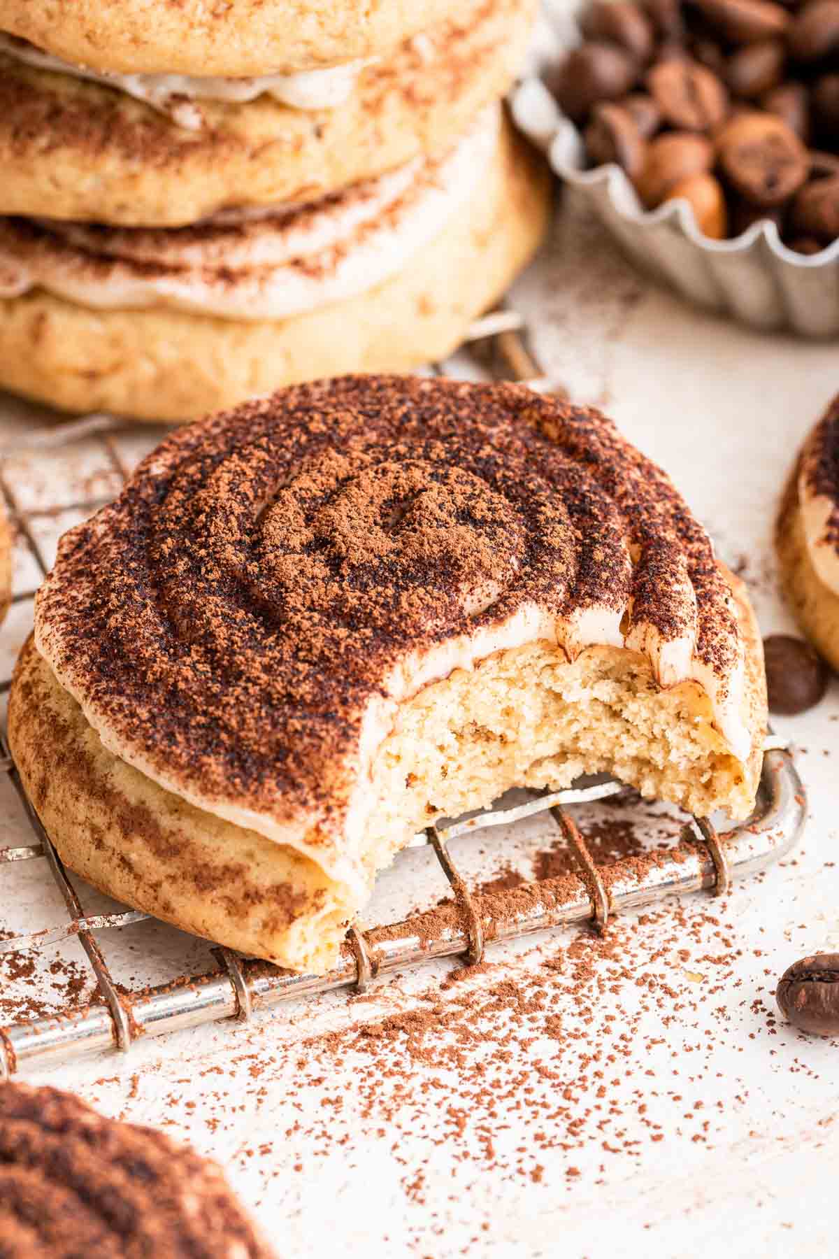 Tiramisu cookies with white frosting and cocoa powder dusted on top.
