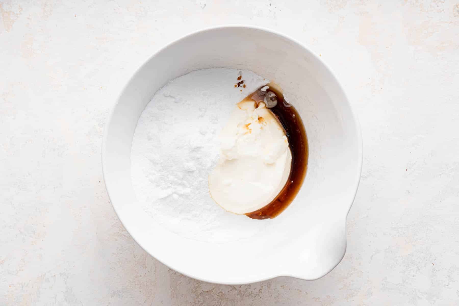 White bowl with sugar, mascarpone, and brown liquid.